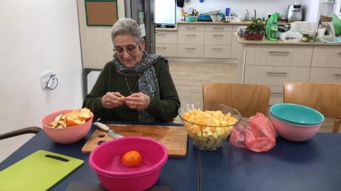 אישה מקלפת וחותכת פירות
